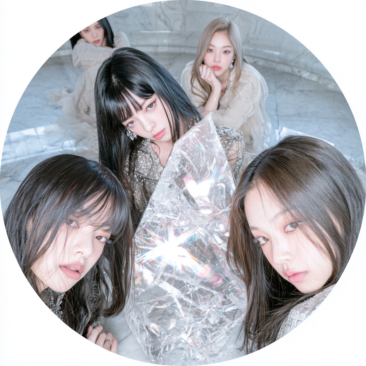 A close-up, circular snapshot of five ECLISSE members gathered on a pale marble floor, all staring intently into the lens. Two members lean closely into the foreground, framing a central member in a shimmering sequined top. Directly in front of her, a large, jagged prismatic crystal refracts sharp shards of light, while two softly focused members in sheer beige garments sit in the background.